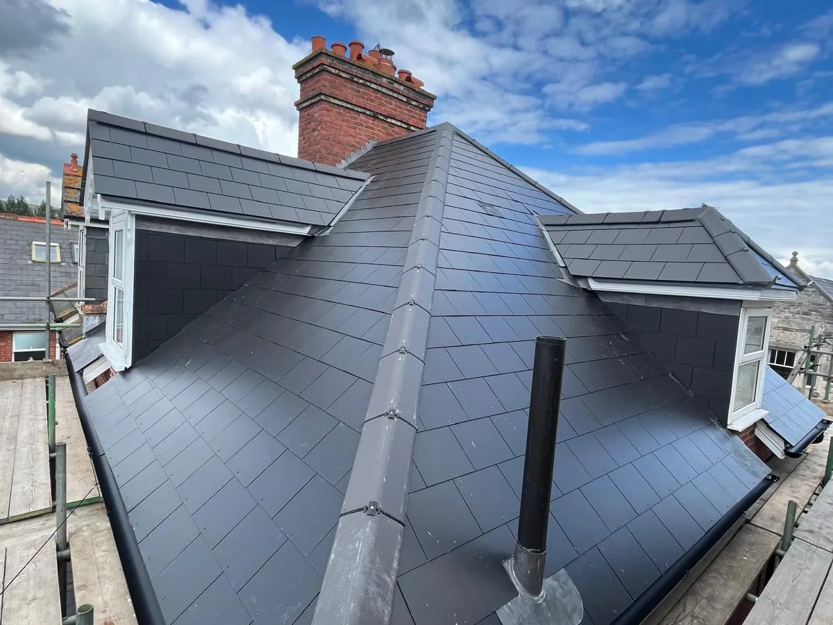 Man-made slate re-roof, with dry ridge system and timber fascia repaired and painted.